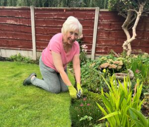 Barbara planting flowers in her garden