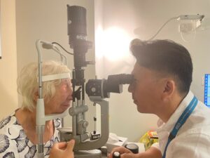 Barbara having eye checked by optician 