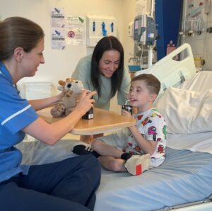 Harry on hospital bed with mother talking to nurse