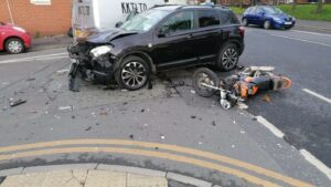 Aftermath of a road traffic collision with a damaged car and motorbike