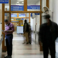 Hospital corridor with people walking down it