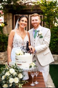 Martyn and his wife at their wedding day cutting the cake