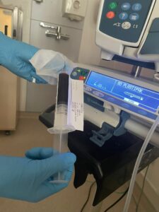 Vial of blood being held by gloved hands