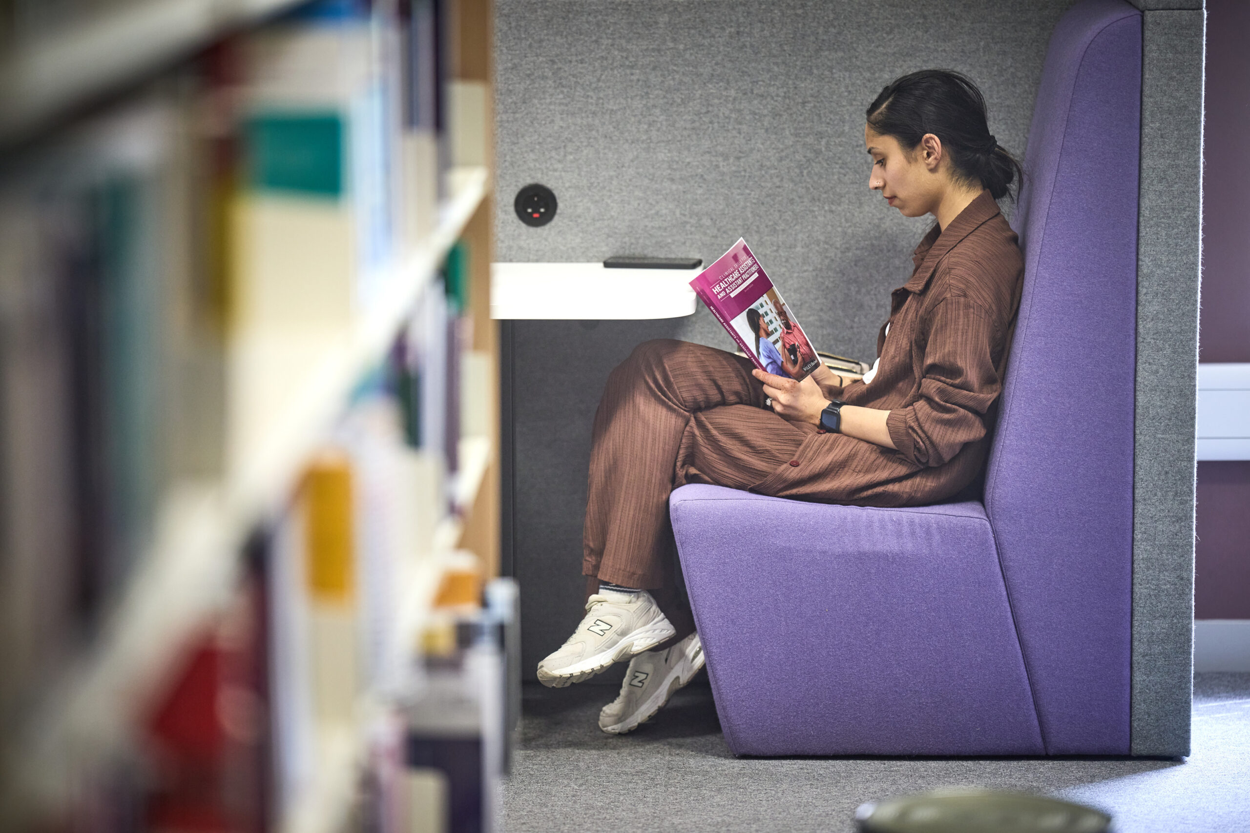 Woman sat reading in a library