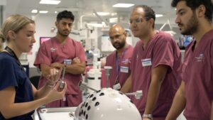 Group of trainees around robotics machine