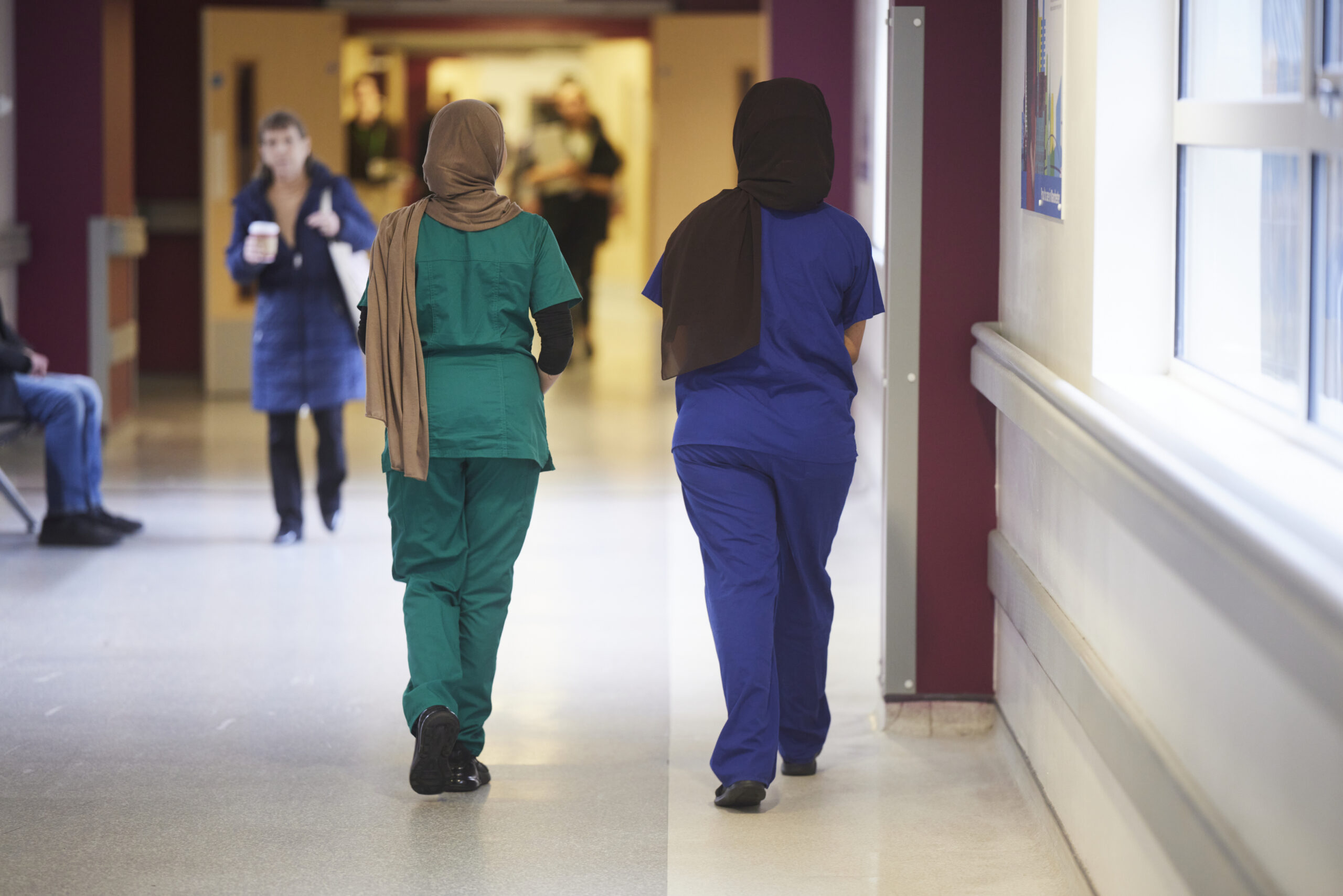 Two NHS members of staff walking down a corridor