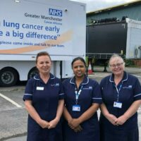 Three staff members stood outside the Lung Cancer Screening mobile clinic.