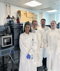 Four people wearing white lab coats.