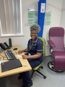 Woman working at computer, smiling to camera