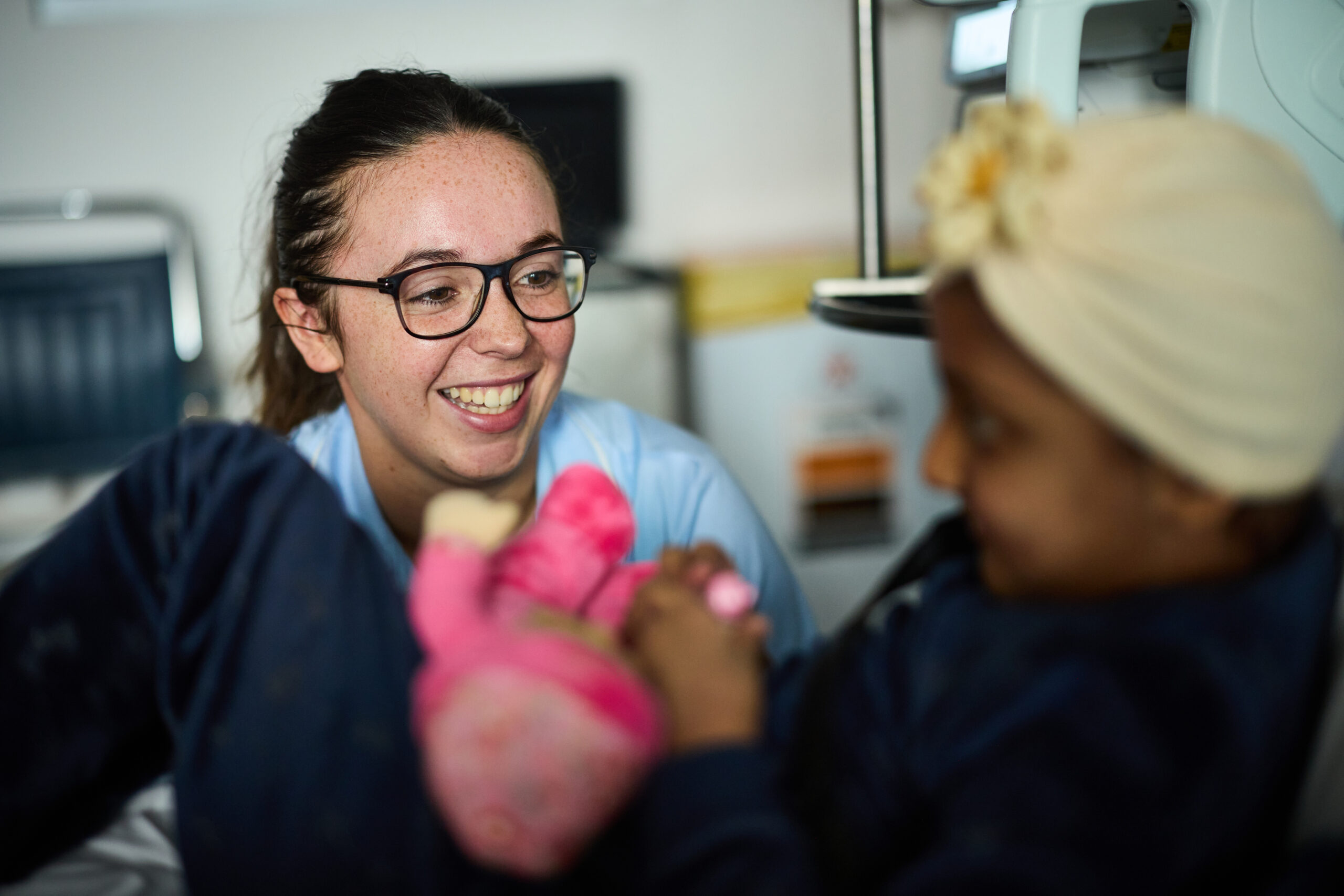 Nurse smiling at child in a hospital bed.