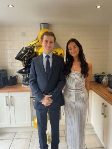 Two people dressed smartly and smiling to camera.