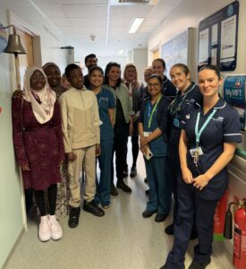 Group of people stood in hospital corridor.