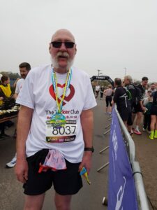 Man wearing a medal and a number at a ran.
