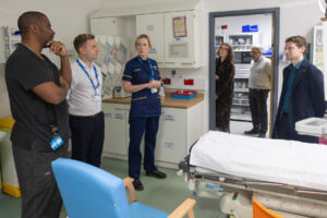 Group of medical staff talking to MP in hospital room