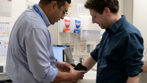Doctor holding dermatology device against arm of Connor Rand MP