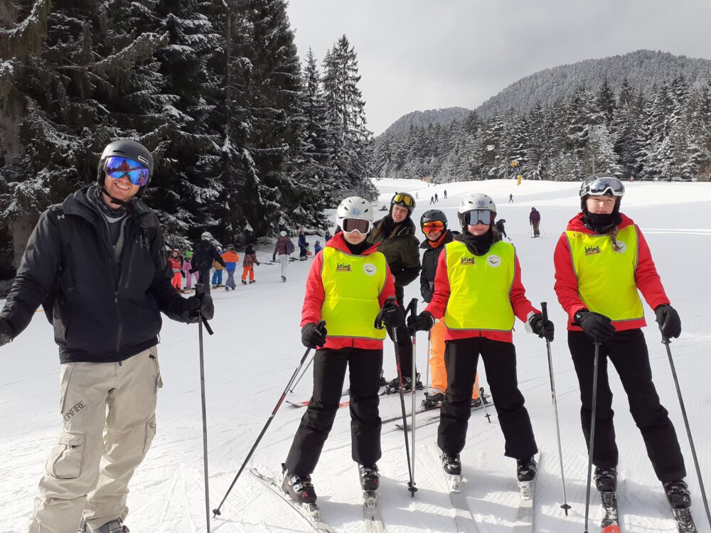 Three teenagers on skis with an instructor